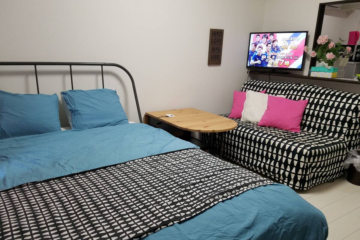 Une chambre d’hôtel avec un lit, un canapé, une petite table et un téléviseur.