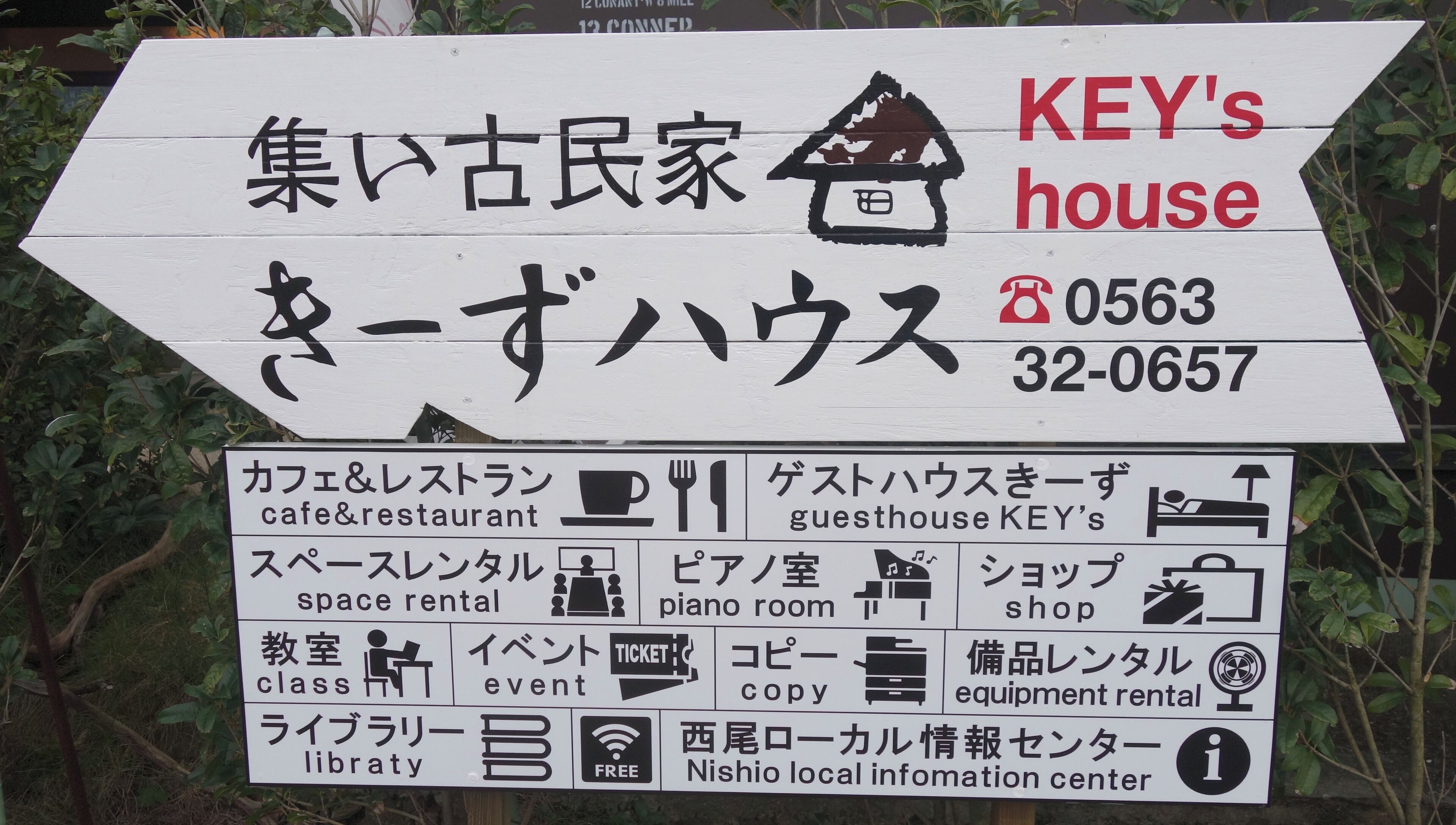 Señal direccional para una casa de huéspedes llamada KEY'S house con los números de contacto 0563 y 32-0657.