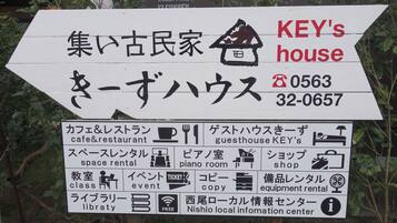 Señal direccional para una casa de huéspedes llamada KEY'S house con los números de contacto 0563 y 32-0657.