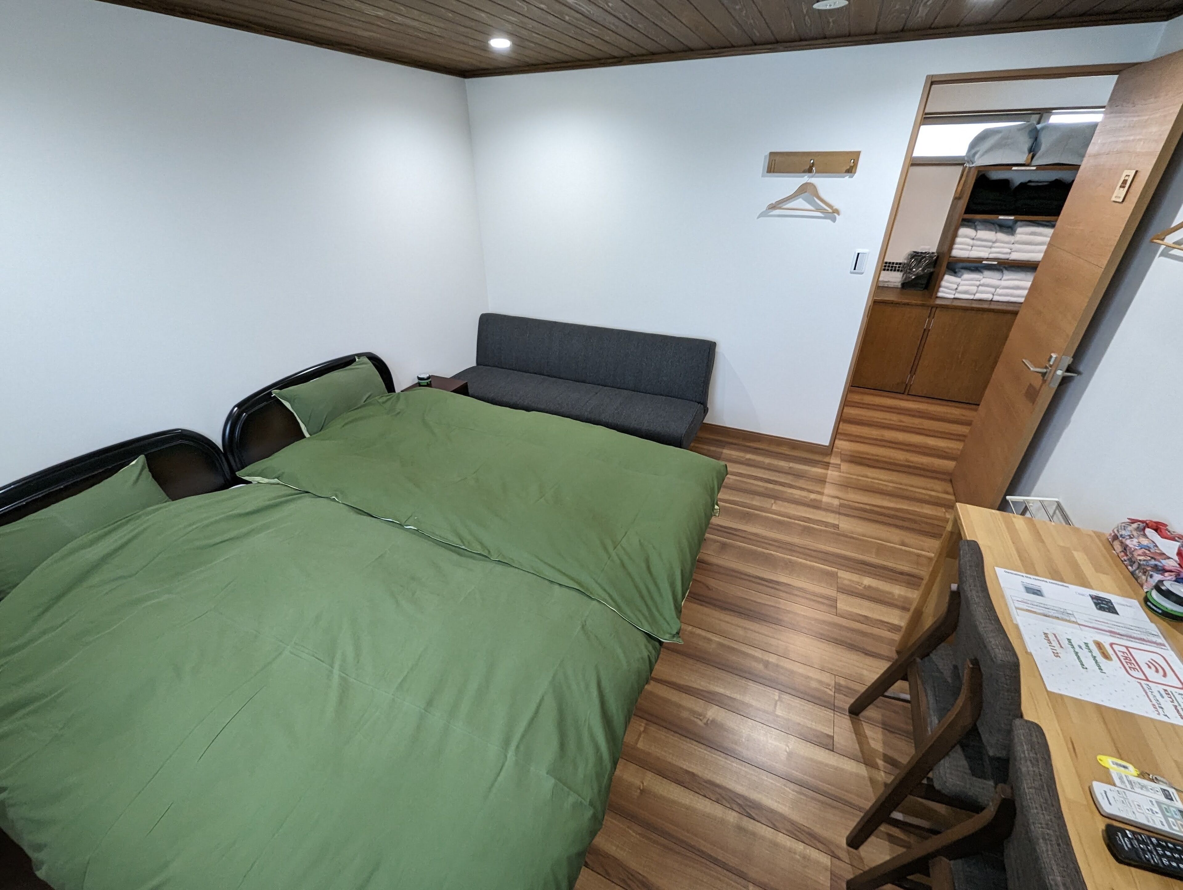A small, neatly arranged bedroom with a bed, a desk, and a wardrobe.