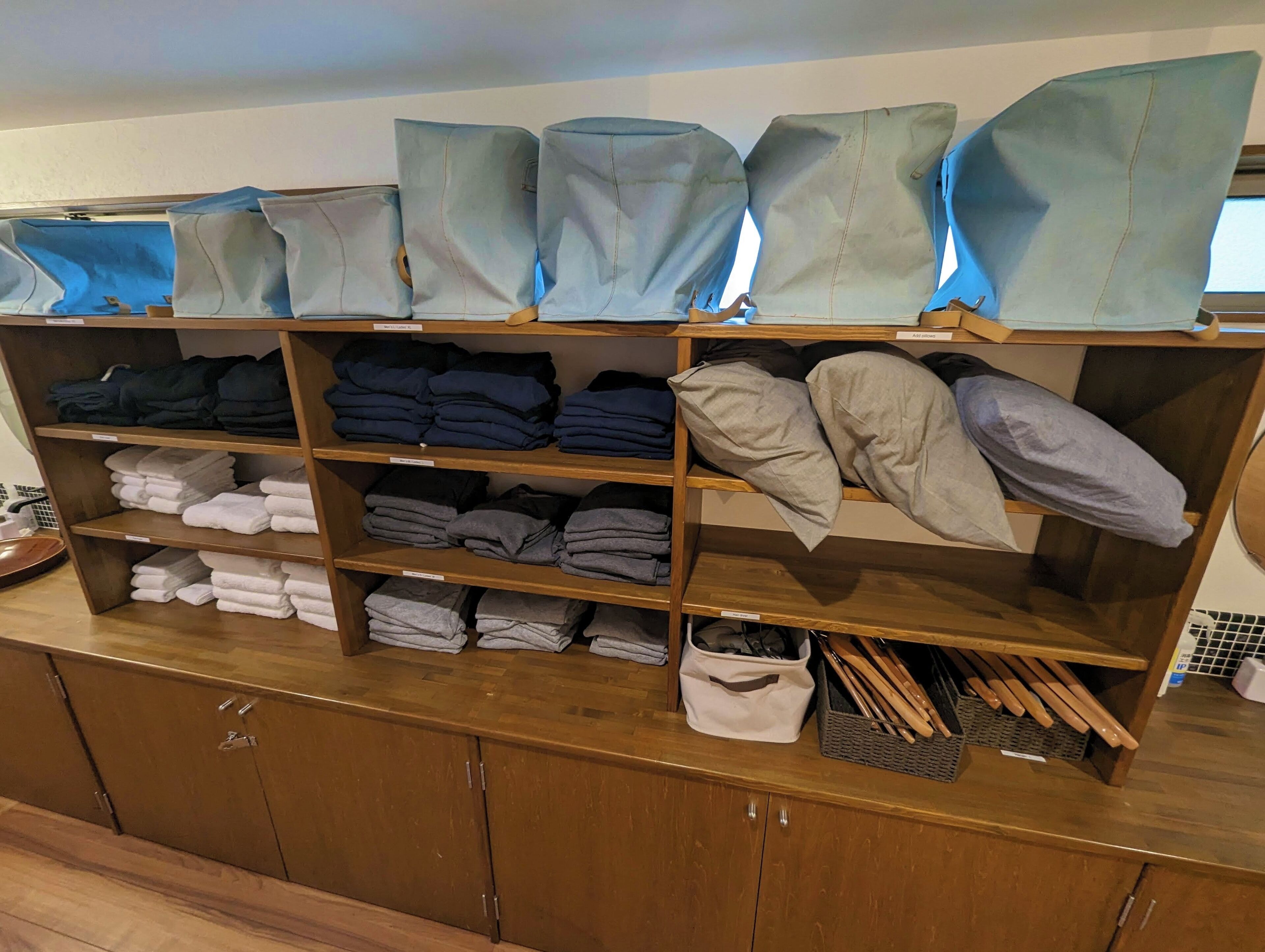 Una tienda de ropa ordenada, con estantes llenos de prendas dobladas y una gran variedad de artículos a la vista.