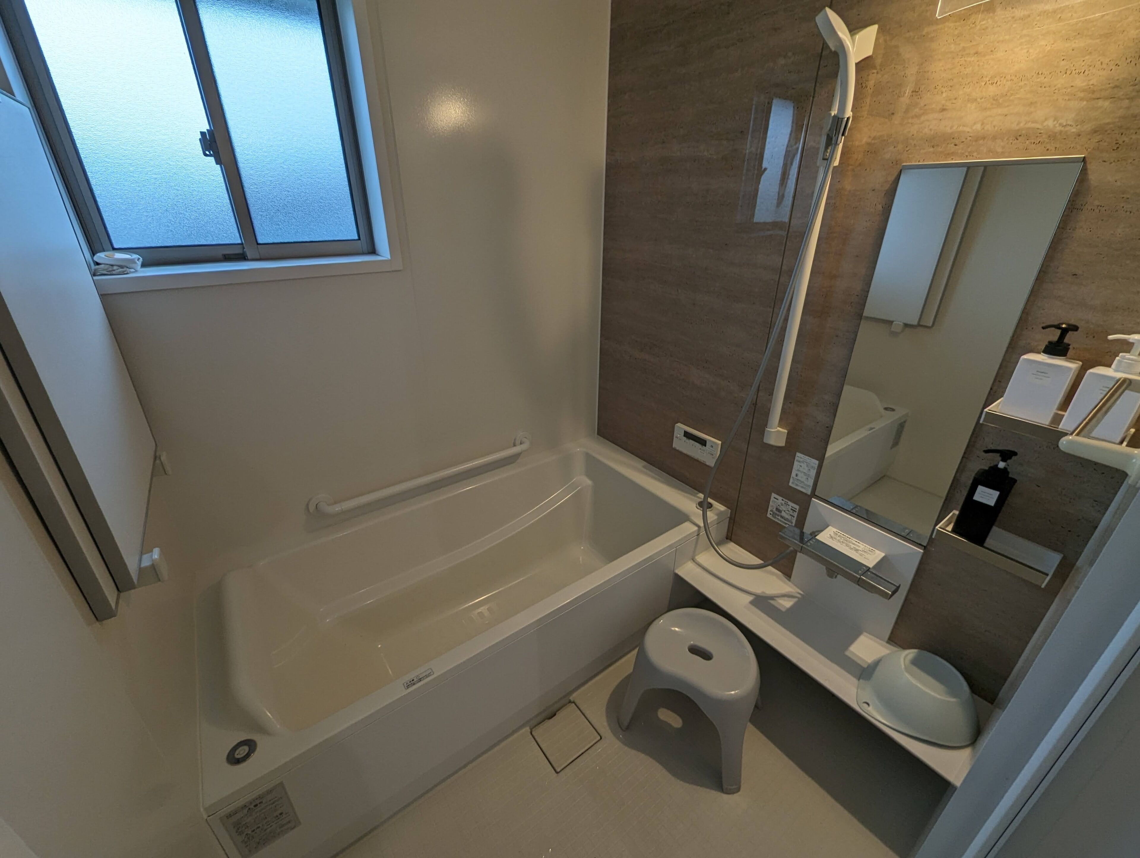 A modern bathroom with a bathtub, a toilet, and a shower.