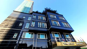 Un hôtel moderne, avec une façade sombre, de nombreux balcons et une enseigne indiquant « WORLD HOTEL ».
