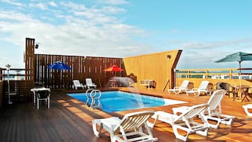 Een seizoensgebonden buitenzwembad, parasols voor strand/zwembad