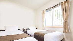 A hotel room with two beds, a large window with curtains, and a wooden floor. - Yanbaru Forest Hills (Motobu)