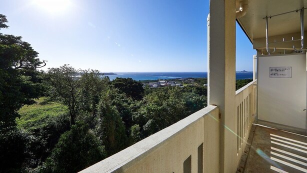A balcony with a view of the sea and greenery. - Yanbaru Forest Hills (Motobu)