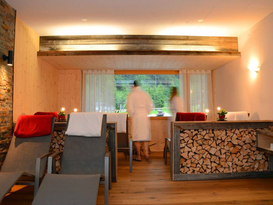 Una stanza accogliente con soffitto in legno, un'area pranzo con tavolo e sedie, e una vista dalla finestra.