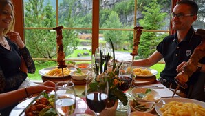 A dining table with various dishes, glasses, and a view of a mountainous landscape through large windows.