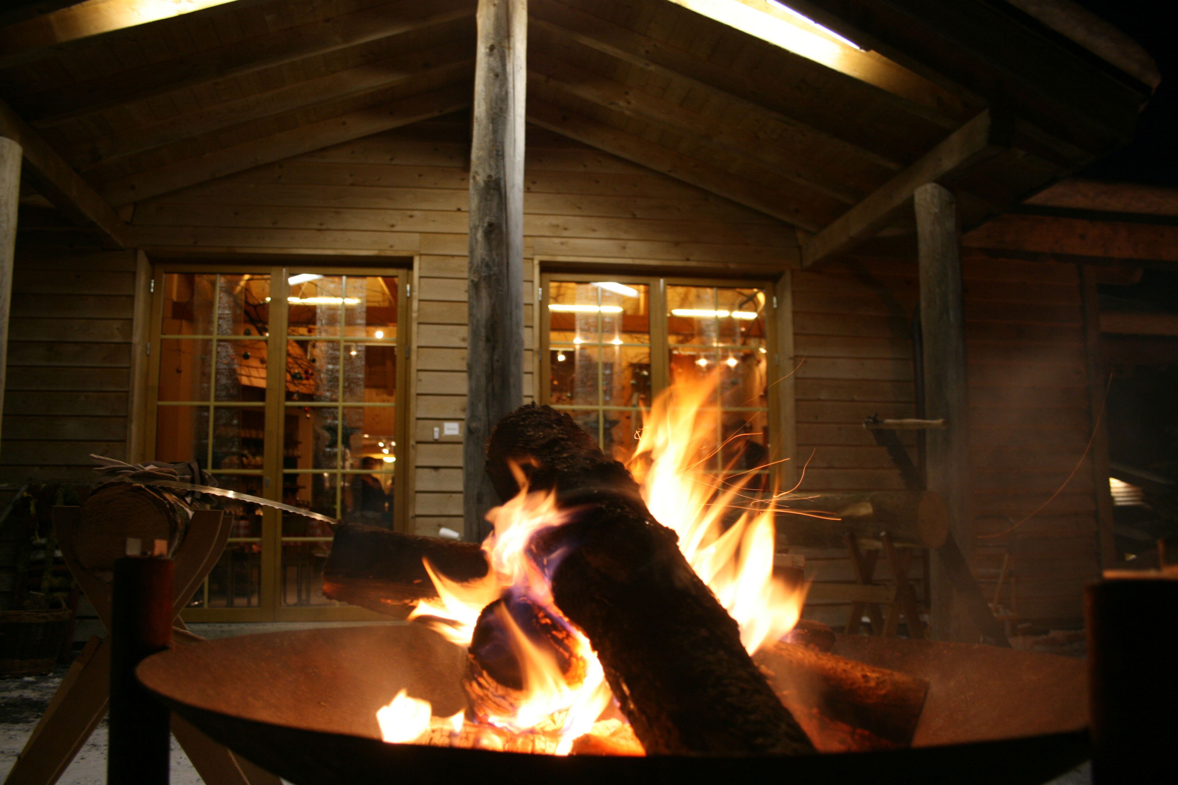 Un bâtiment en bois avec un grand foyer au premier plan.