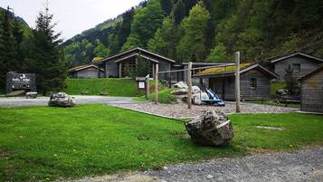 Un chalet rustique avec des cabanes en bois, une aire de jeux et un panneau indiquant « Husky Lodge ».