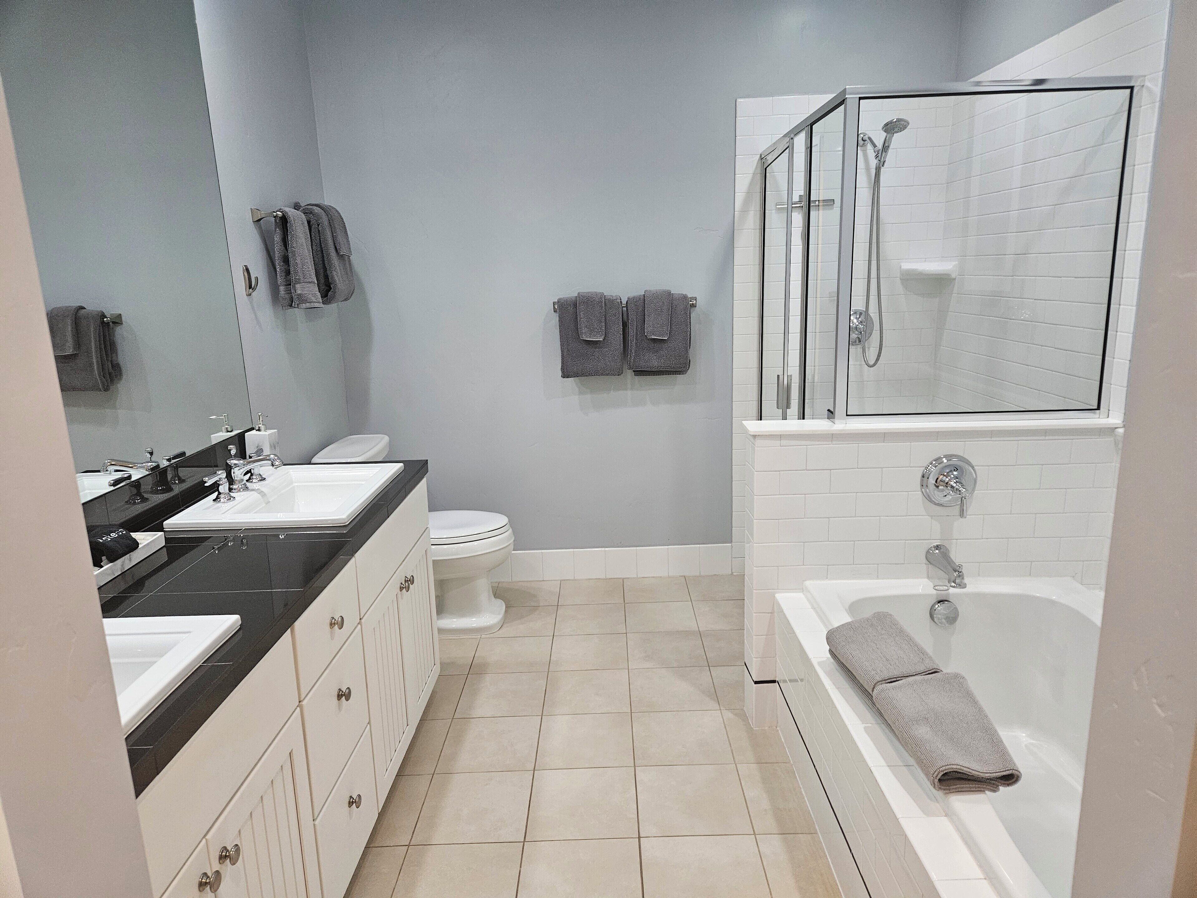 A modern bathroom with a shower, toilet, and vanity.