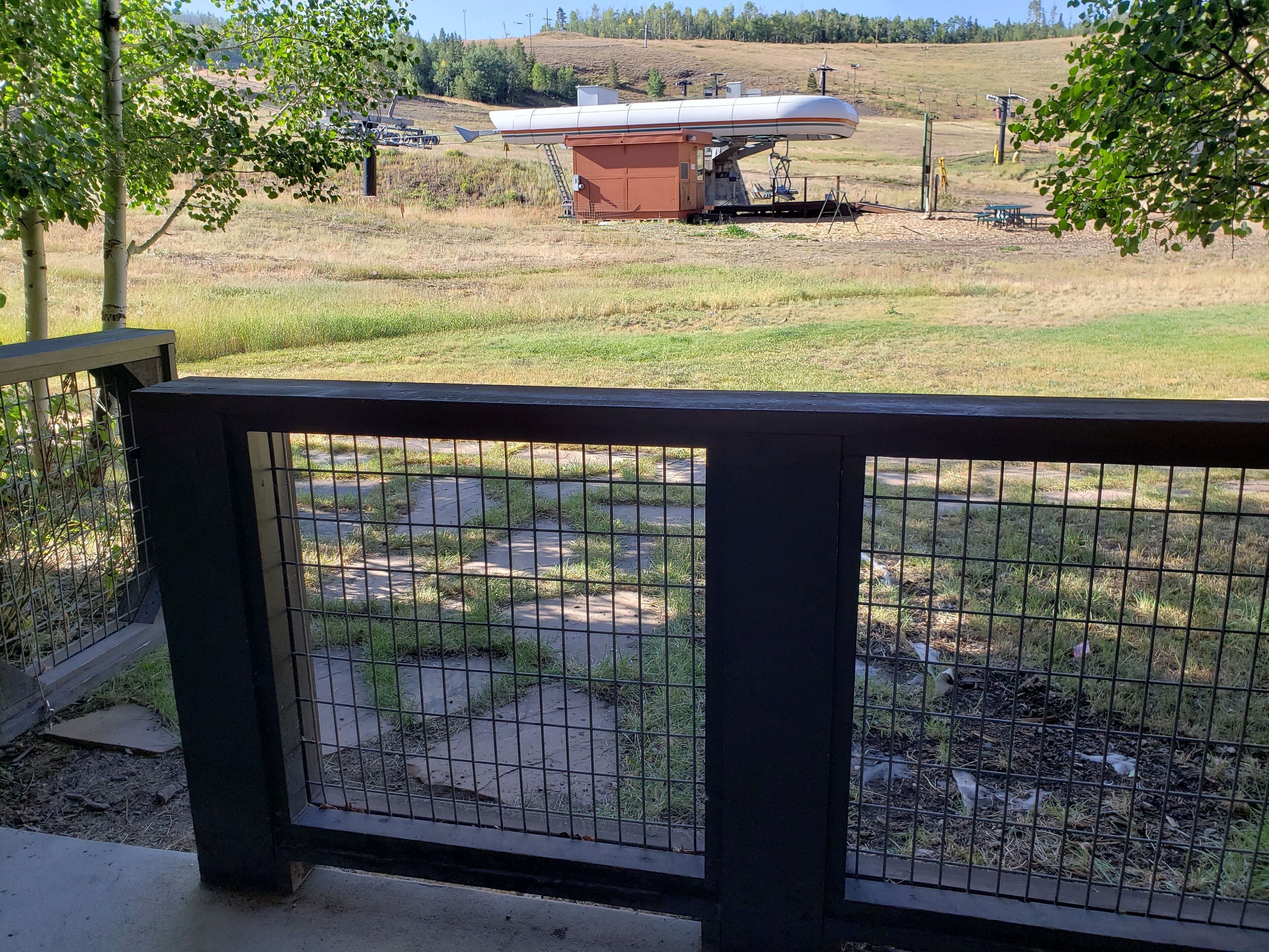 A fenced area with a view of a large building and a landscape in the background.