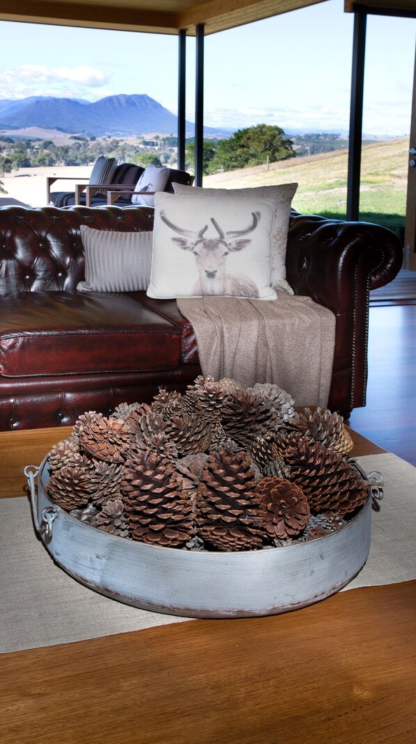 Un sofá de cuero con un cojín decorativo y un centro de mesa con una piña.