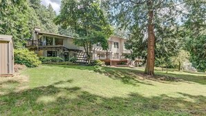 A two-story house with a deck and a covered outdoor area. - POWER ON - The Forest Rooms -- A Peaceful Oasis close to everything (Issaquah)