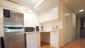 A compact kitchen with a stainless steel refrigerator, a microwave, a coffee maker, and a sink. - POWER ON - The Forest Rooms -- A Peaceful Oasis close to everything (Issaquah)