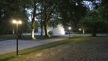 A pathway leading to a building with a gravel area and trees.
