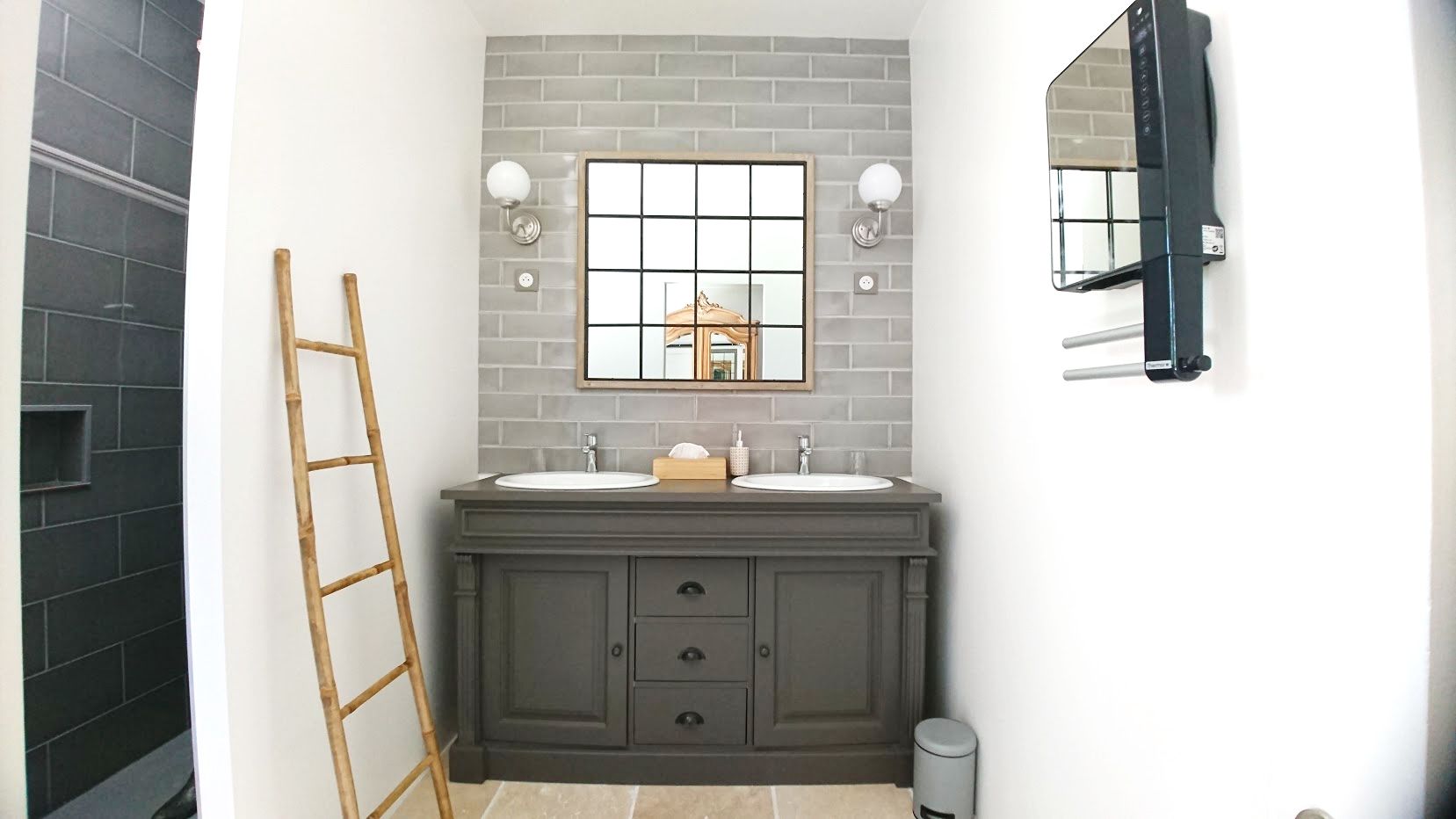 A bathroom with a double sink vanity, a mirror, and a towel rack.