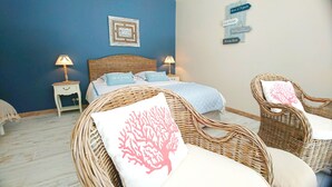 Een slaapkamer met een bed, twee nachtkastjes, een rieten stoel en een muur met borden met richtingaanwijzingen.