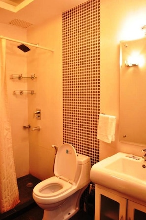A bathroom with a toilet, sink, and shower. - Hotel Solo Victoria (New Delhi)