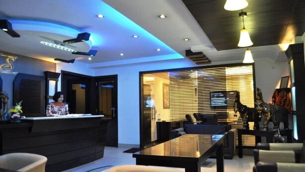 A modern hotel lobby with a reception desk, seating area, and a dining space. - Hotel Solo Victoria (New Delhi)