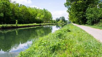 A calm river with a grassy path alongside.