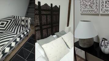 Una cama con un edredón estampado, un cabecero con diseños intrincados, una mesita de noche con una lámpara y decoración en la pared.