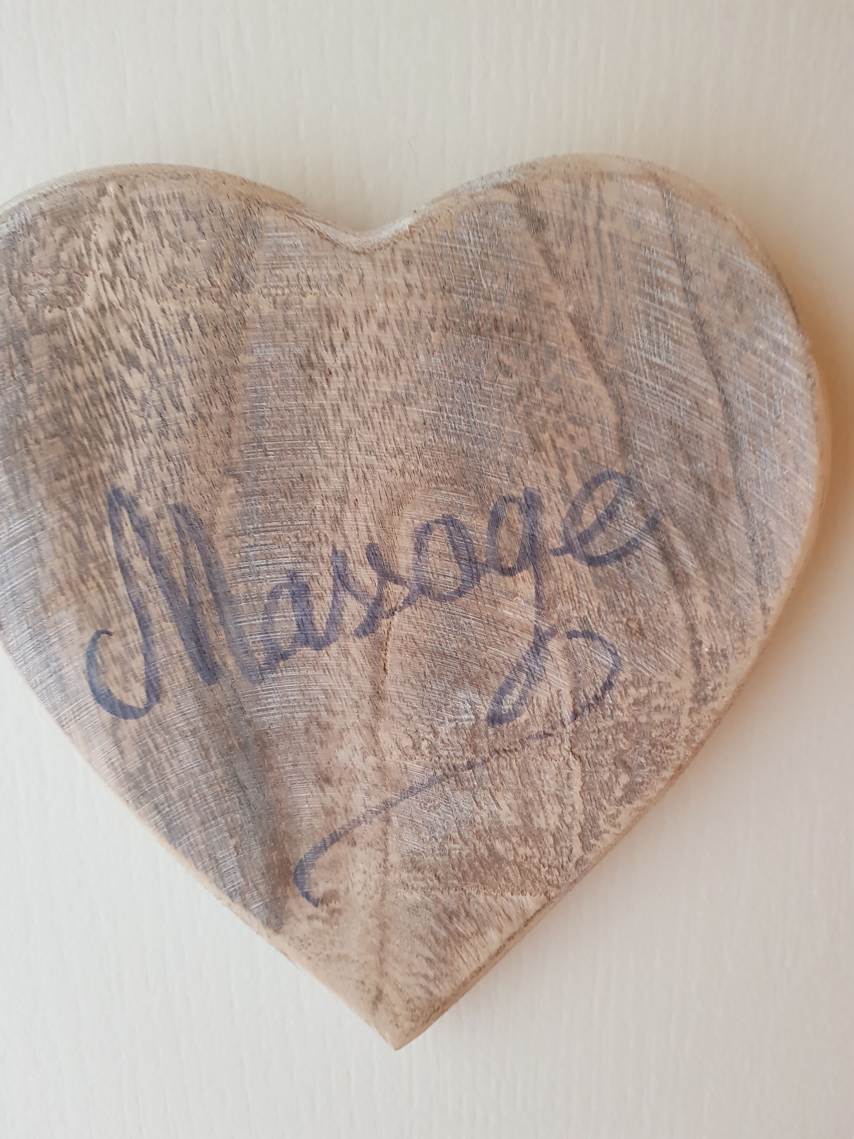 A wooden heart-shaped object with the word "Marriage" engraved on it.