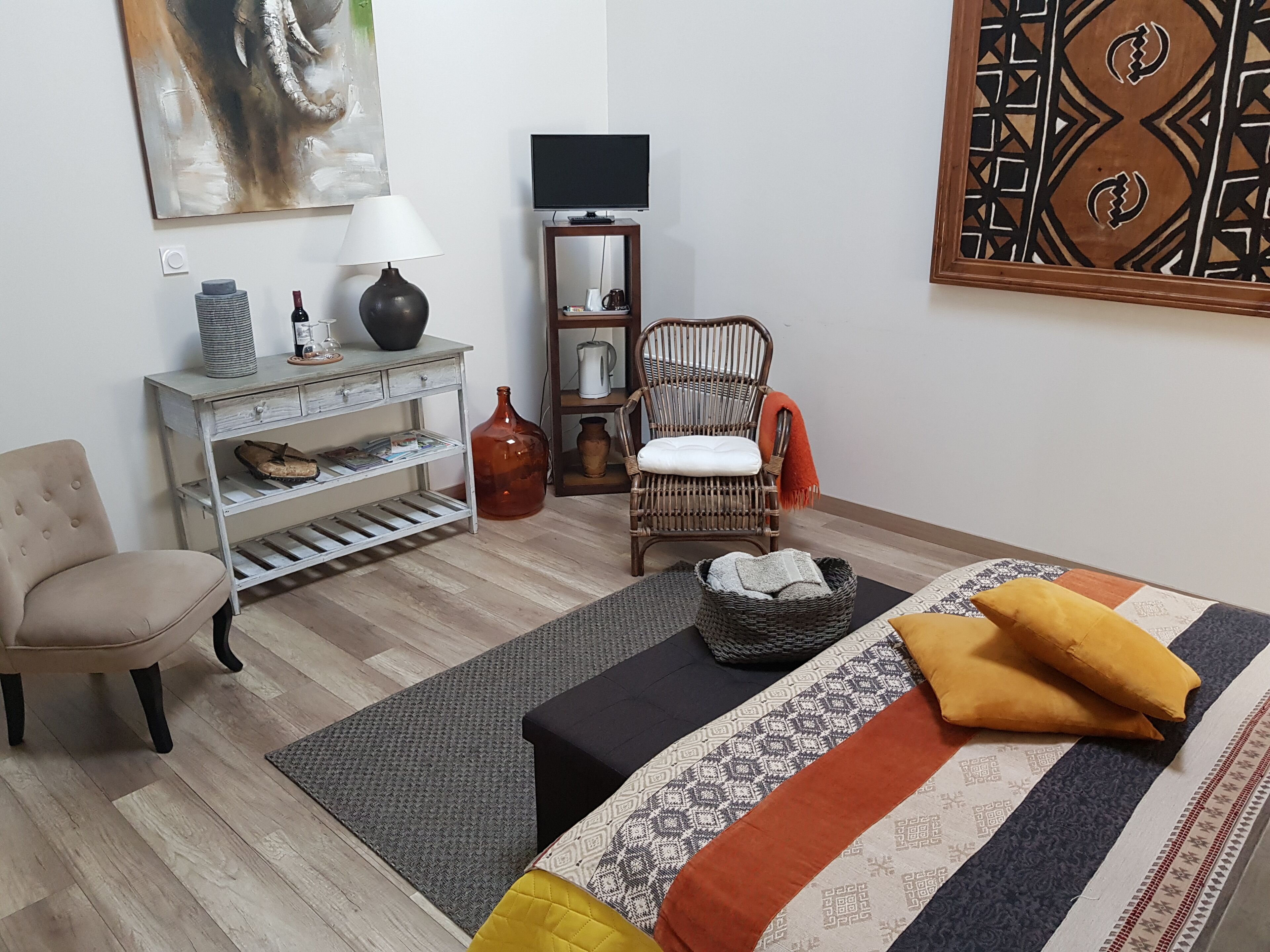 A living room with a sofa, armchair, coffee table, TV, and a decorative wall piece.