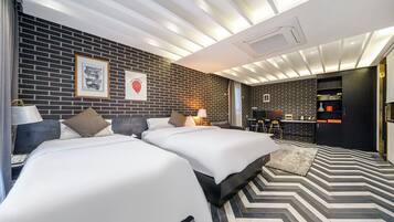 Ein modernes Hotelzimmer mit zwei Betten, einer Essecke und einer Küche.