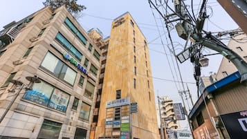 Un edificio de varios pisos con diferentes letreros, incluyendo un hotel y un centro de negocios.