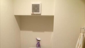 A small, compact bathroom with a white toilet, a pedestal sink, and a handheld sprayer. - Guest House KAN (Tokyo)