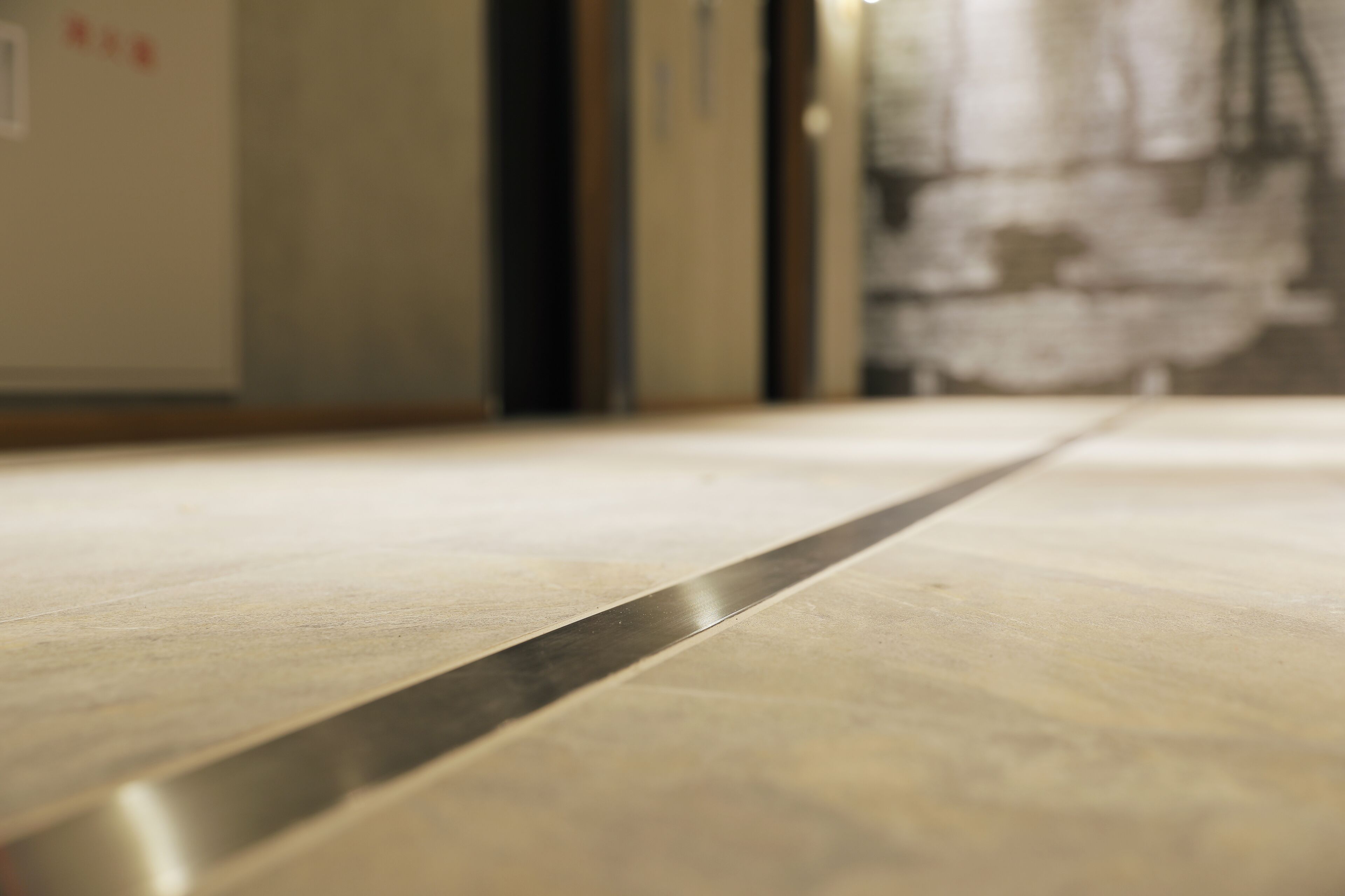 A close-up of a metallic edge, likely part of a door or partition, in a hallway.
