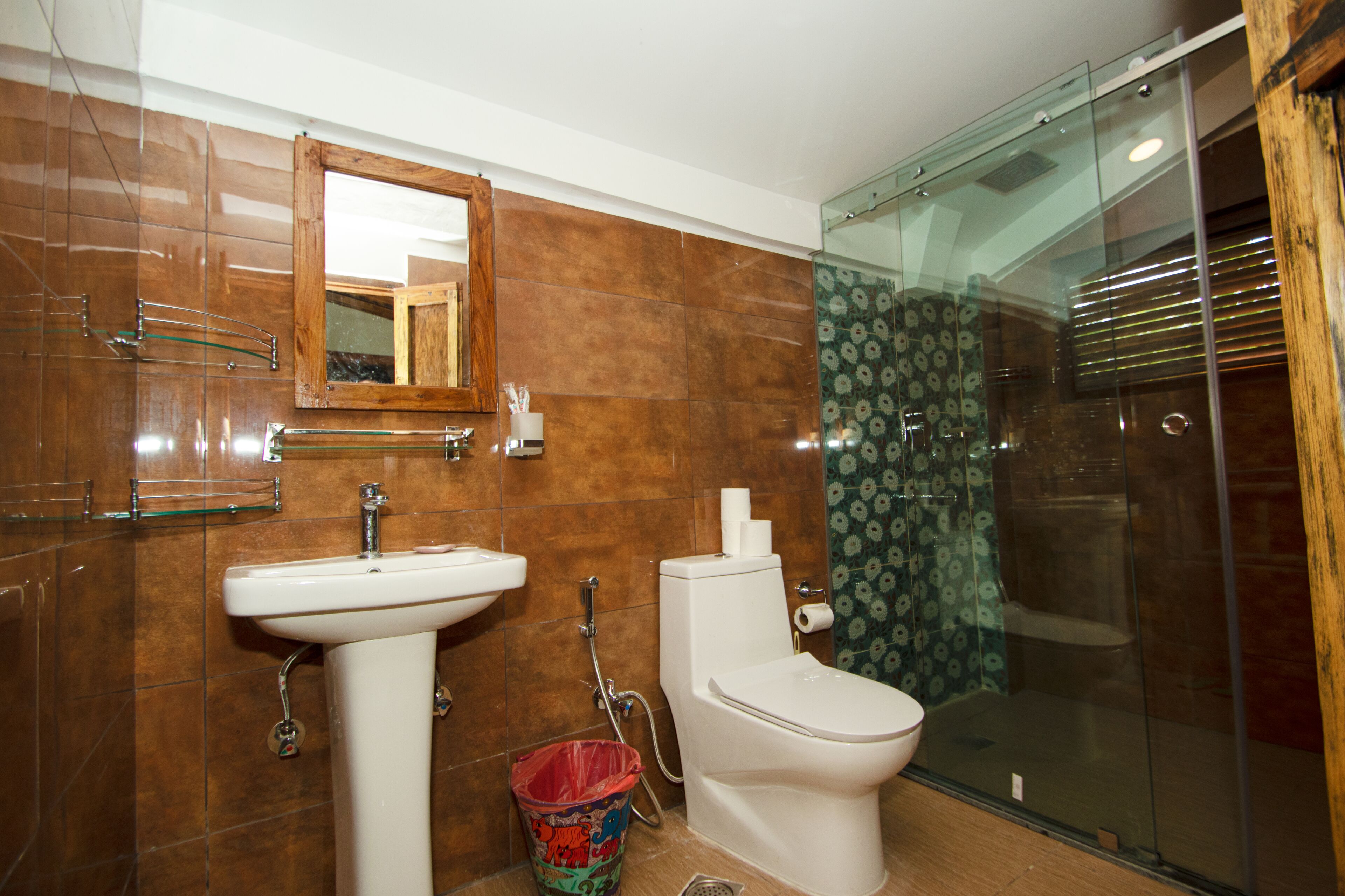 Un baño con lavamanos, inodoro y cabina de ducha de vidrio.