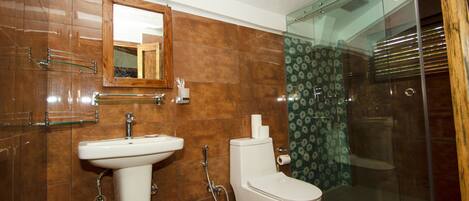 Un baño con lavamanos, inodoro y cabina de ducha de vidrio.