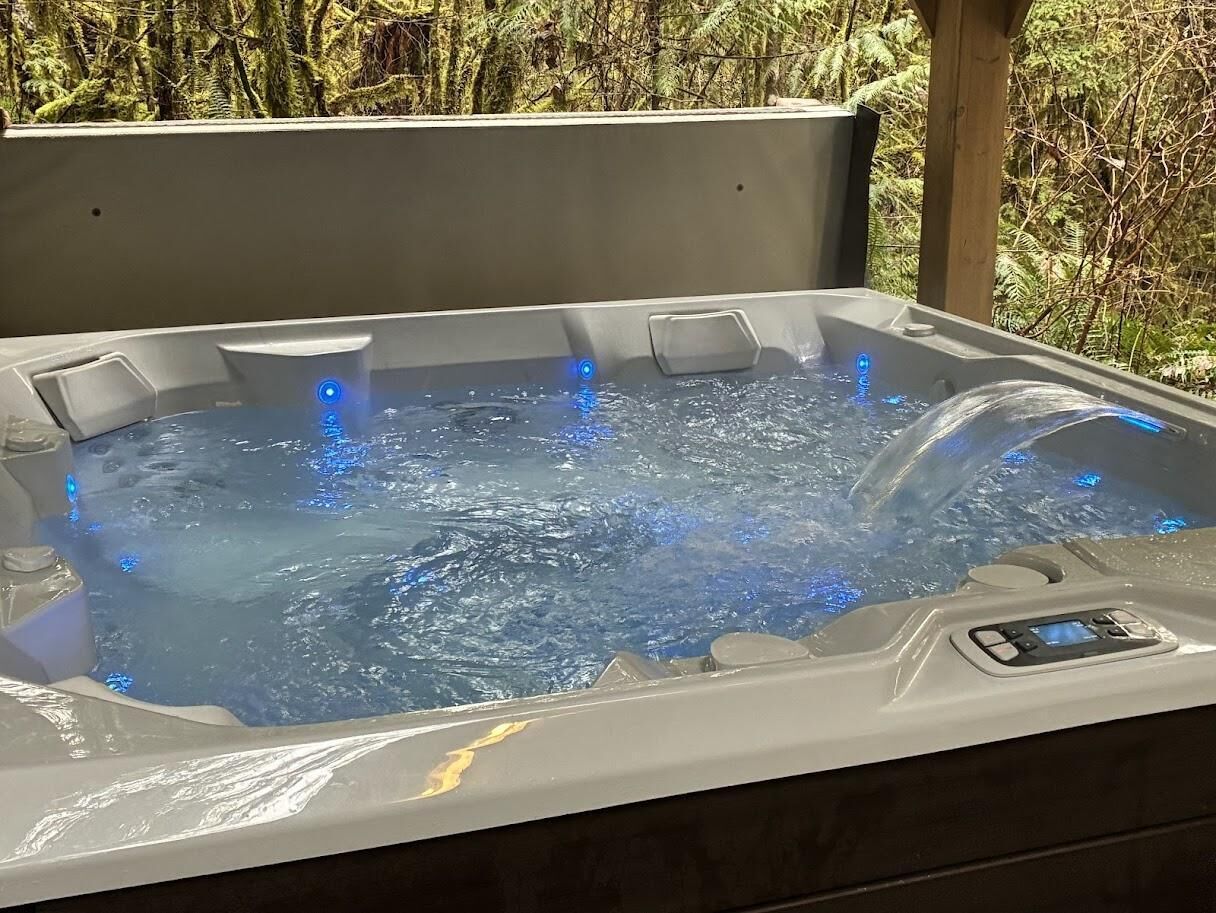A hot tub with a digital control panel and a wooden deck surrounding it.