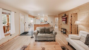 A cozy living room with a sofa, a coffee table, and a kitchen area in the background. - 095GS - Hot Tub - WiFi - Pets Ok - Sleeps 4 (Deming)