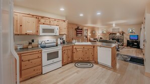 A modern kitchen with wooden cabinets, a microwave, oven, and a sink. - 095GS - Hot Tub - WiFi - Pets Ok - Sleeps 4 (Deming)