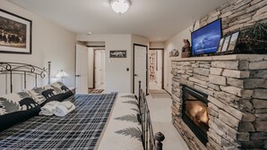 A bedroom with a bed, a fireplace, a television, and a framed picture on the wall. - 89GS - Hot Tub - Pets Ok - WiFi - Sleeps 4 (Deming)