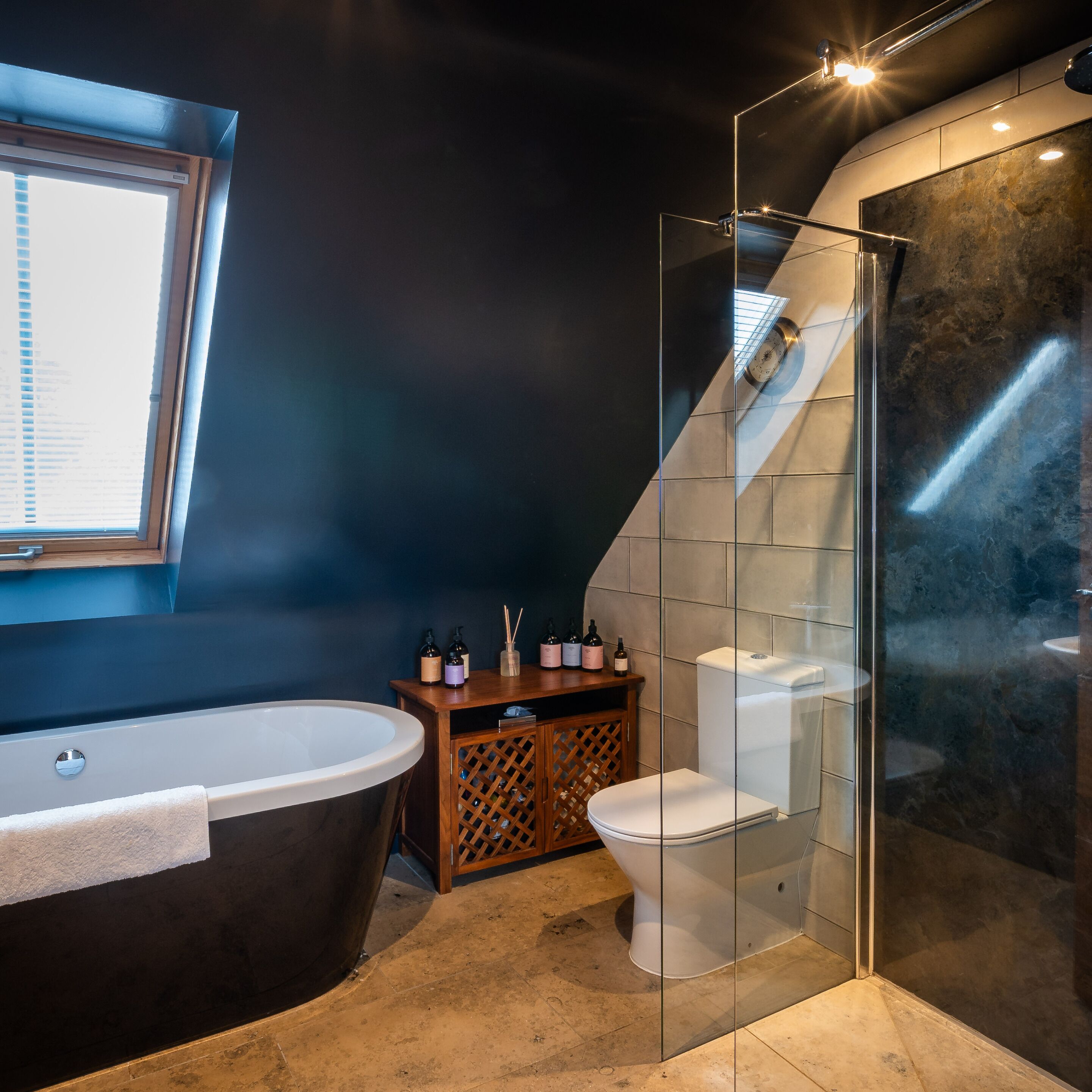 Un baño moderno con una bañera independiente, inodoro y cabina de ducha de vidrio.