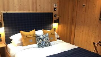 A wooden-paneled room with a bed, a nightstand, and a lamp.