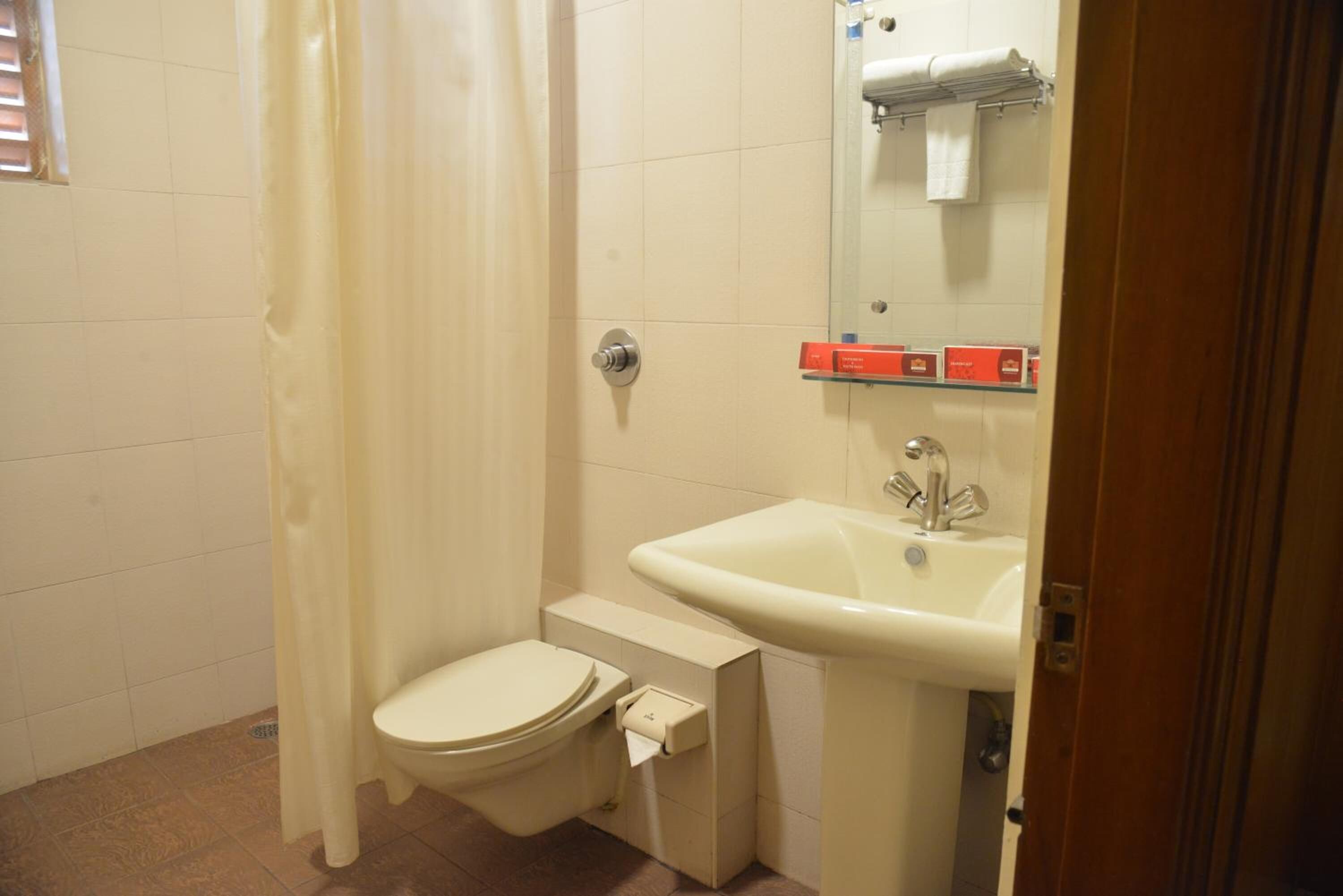 A small bathroom with a toilet, sink, and shower curtain.