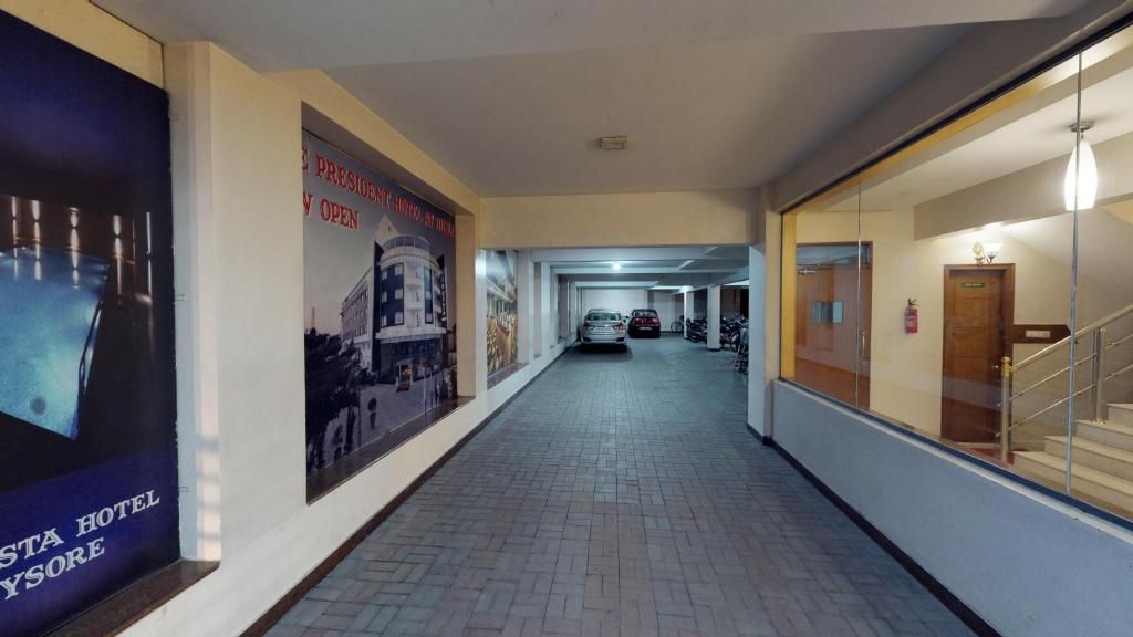 Un passadís d'hotel amb sòl de rajola, un cartell a l'esquerra i una escala a la dreta.