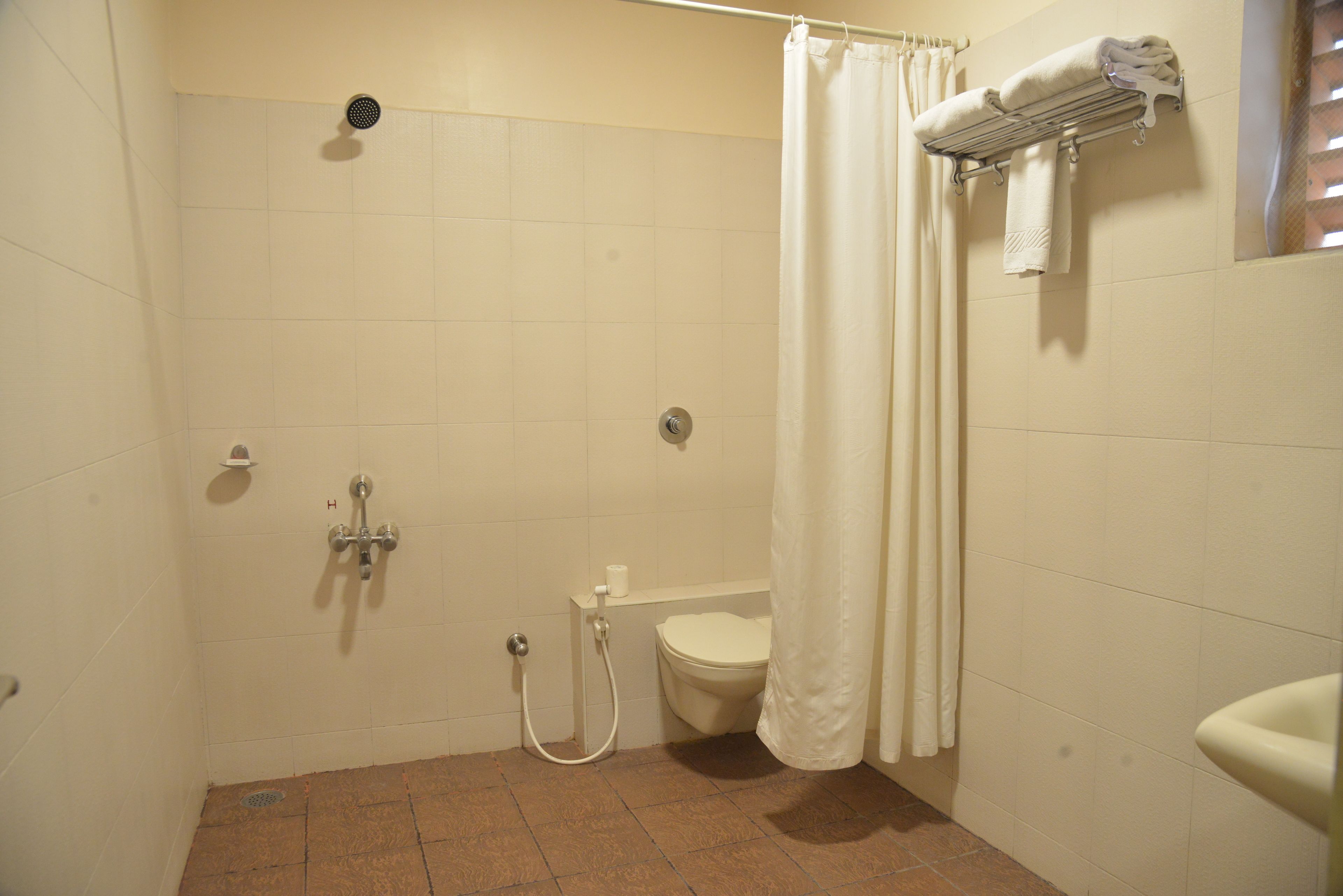 A small, clean bathroom with a shower, toilet, and sink.