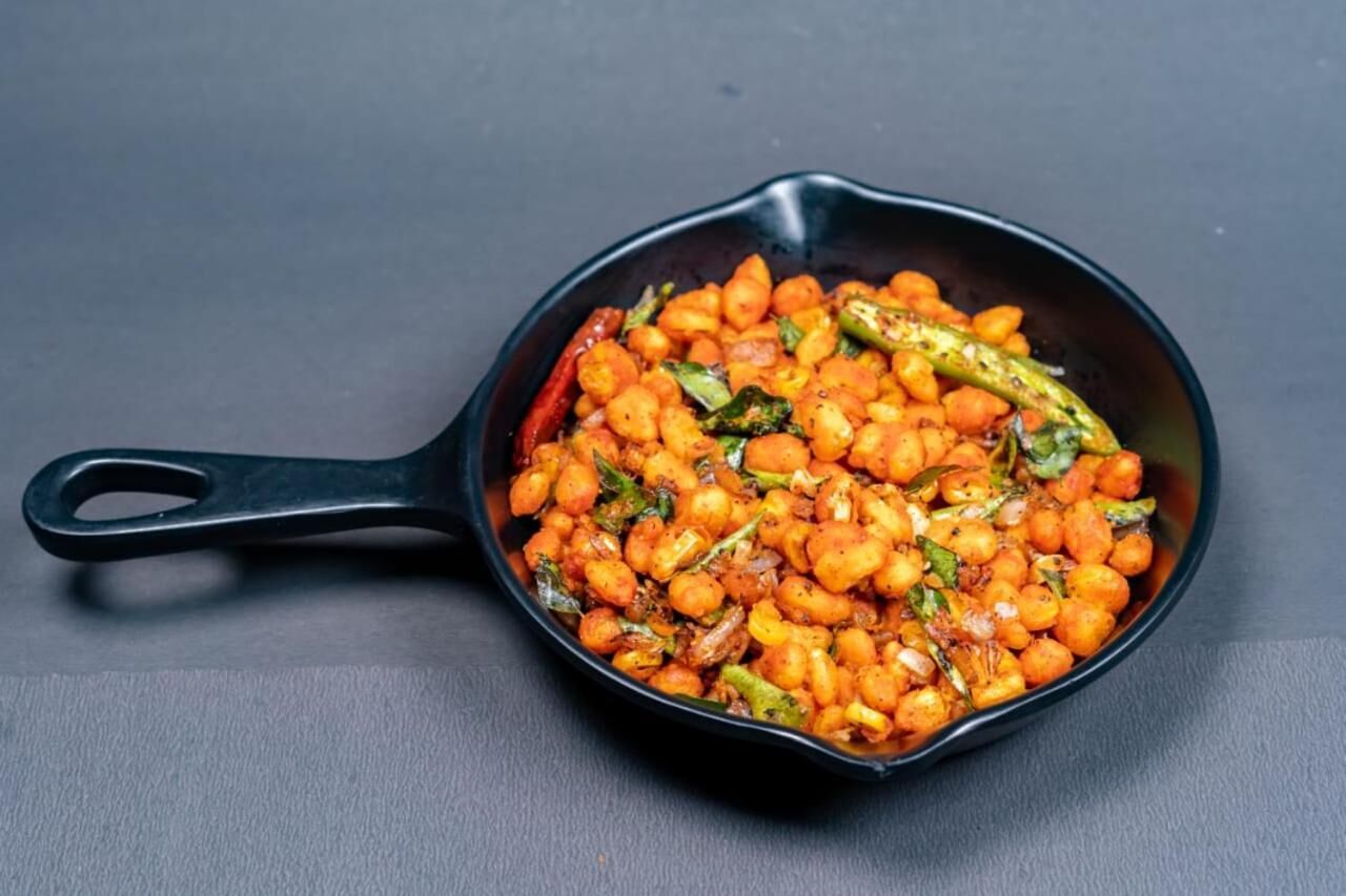 A skillet with a dish of chickpeas and vegetables.