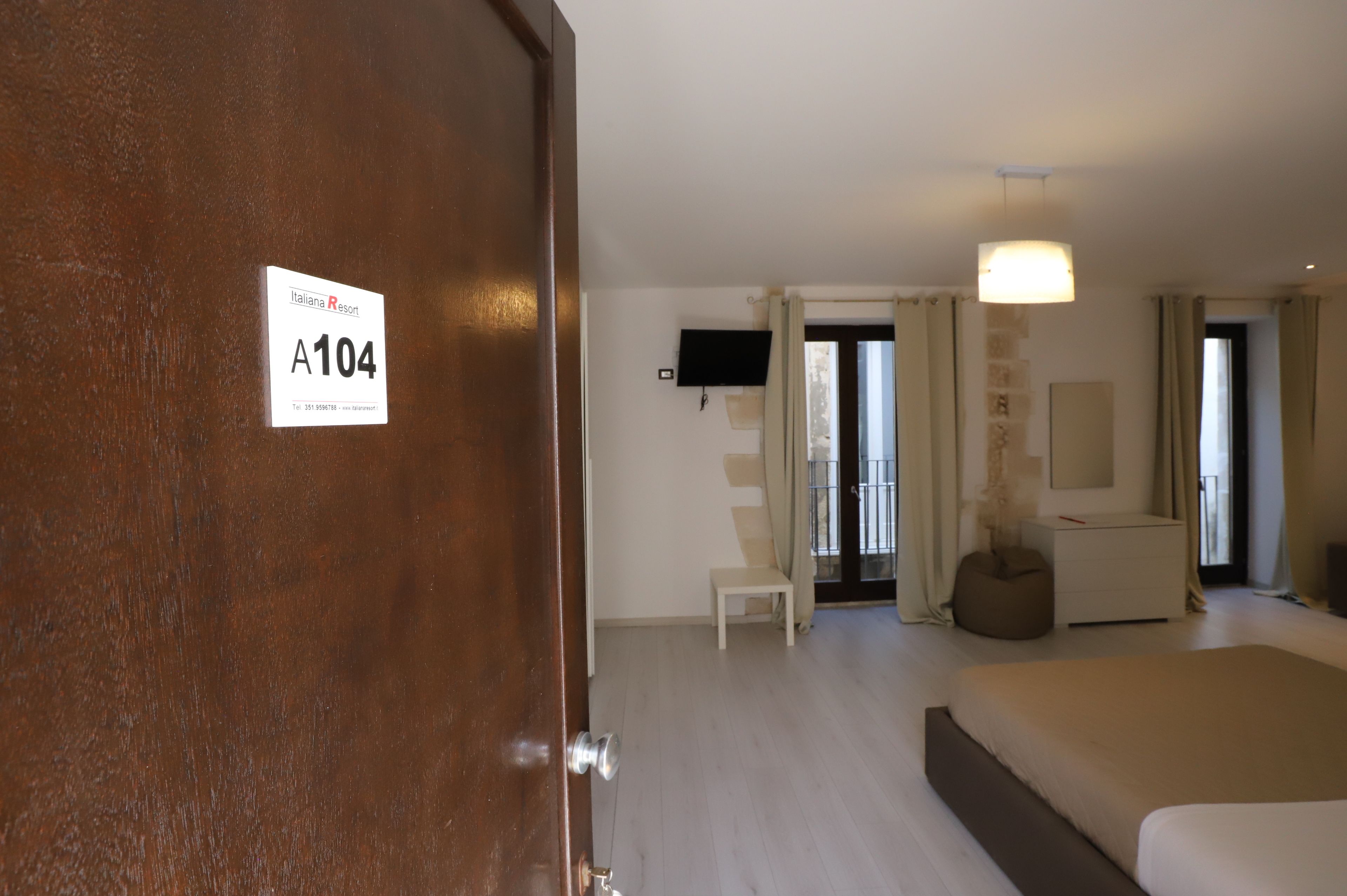 Une chambre d’hôtel avec un lit, une chaise, un bureau et un téléviseur.