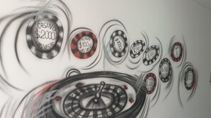 Een muur met een roulette ontwerp, met verschillende fiches met bedragen zoals 200, 100 en 500 dollar.