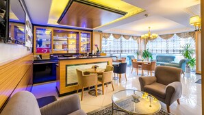 A modern hotel lobby with a reception desk, seating area, and large windows. - My Rose Hotel (Istanbul)
