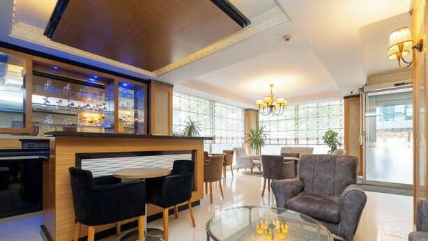 A hotel lobby with a bar area, seating arrangements, and a chandelier. - My Rose Hotel (Istanbul)