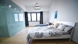 A bedroom with a bed, a wardrobe, a window, and an air conditioner. - GT Home Encorp Strand Residence (Petaling Jaya)