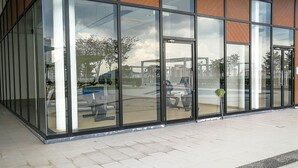 A modern building with large glass windows and a wooden facade. - GT Home Encorp Strand Residence (Petaling Jaya)
